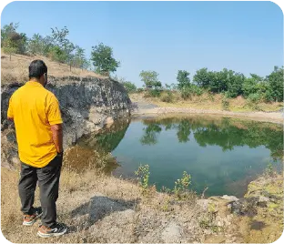 Volunteer inspecting water source near plantation site